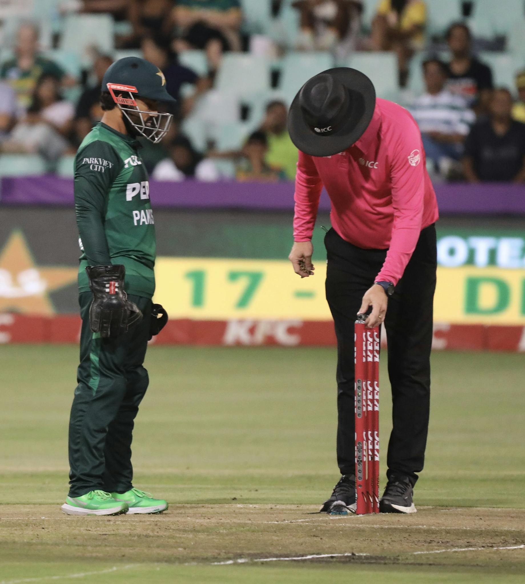 A cricket umpire and player in action during a live match, highlighting sportsmanship.